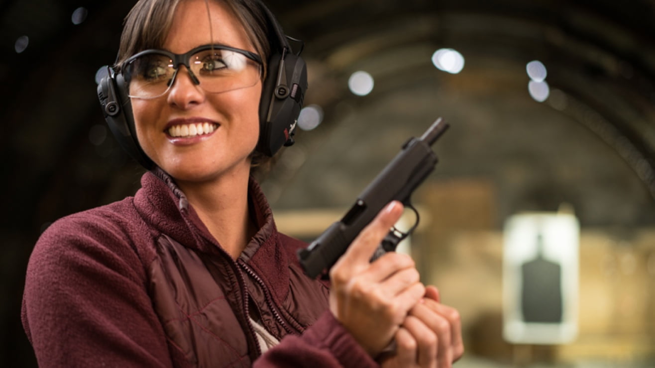 Amateur shooter smiling holding a handgun