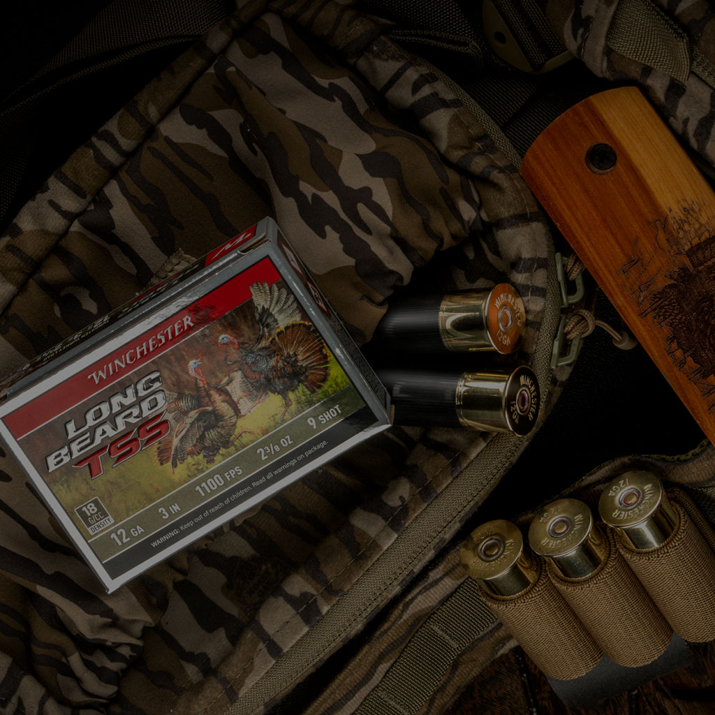 Long Beard TSS ammunition box next to a shotshell ammo belt with several shells laying out